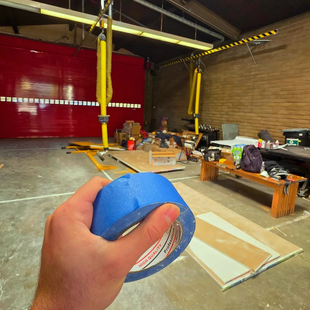 Hand holding a roll of EitanCo blue painter's tape at the Los Angeles Fire Department