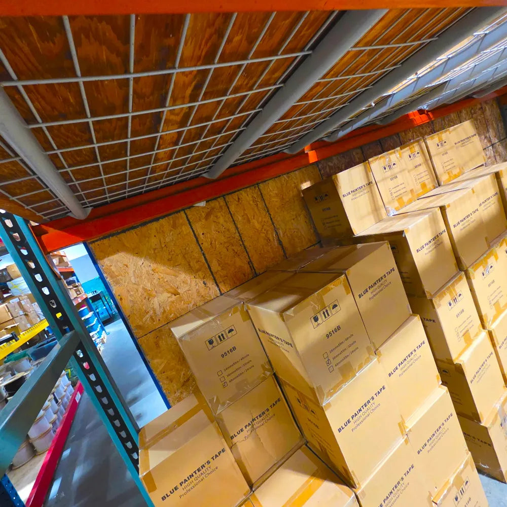 Boxes of blue painter's tape stacked on the EitanCo warehouse racks